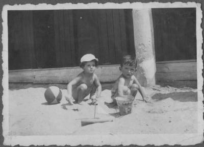 [Vladimir Herzog e menino brincam na areia]