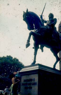 [Clarice e Ivo Herzog criança em frente a estátua de rei sobre cavalo]