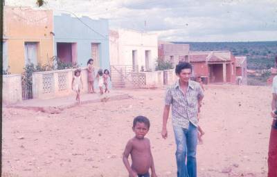 [Homem e crianças em rua de terra]
