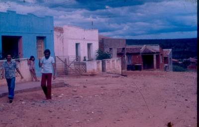 [Yves Winandy, de camiseta branca, e moradores locais em frente a casas]