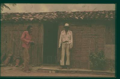 [Dois homens em frente a uma casa]