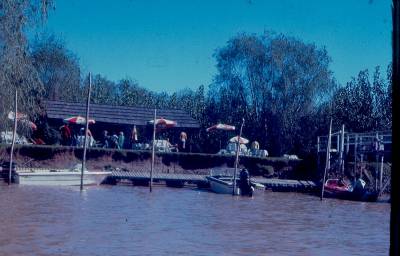 [Restaurante e barcos à margem de um rio]