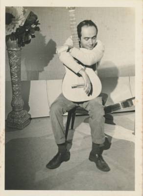 [Vladimir Herzog posa abraçando violão]